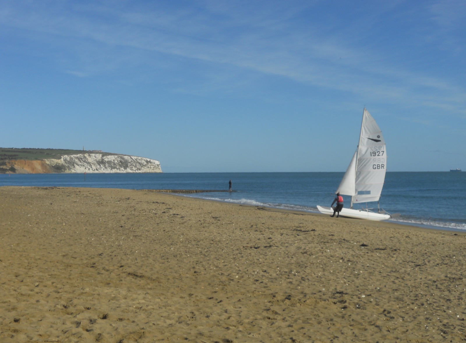 Sandown beach with small boats and Culver Cliff in the distance